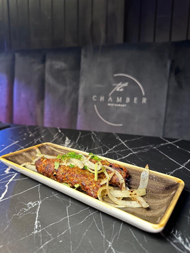 Juicy beef Adana kebab skewers grilled to perfection, served with fresh garnishes.