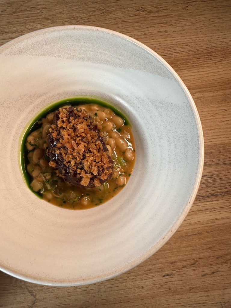 Slow-braised sticky pork cheek nestled in a rich cassoulet, topped with crispy sourdough crumb.