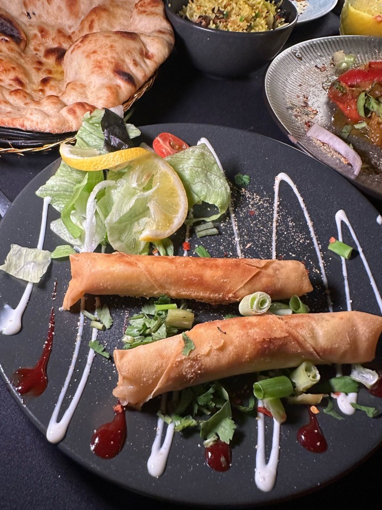 Crispy golden chicken spring roll served with a side of dipping sauce at Chester’s Lounge.