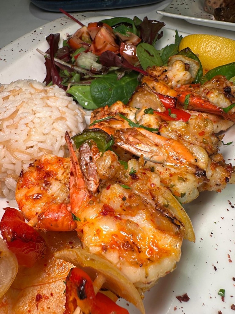 Skewered jumbo king prawns chargrilled to perfection, served with fluffy rice and a fresh side salad at Turknaz Restaurant.