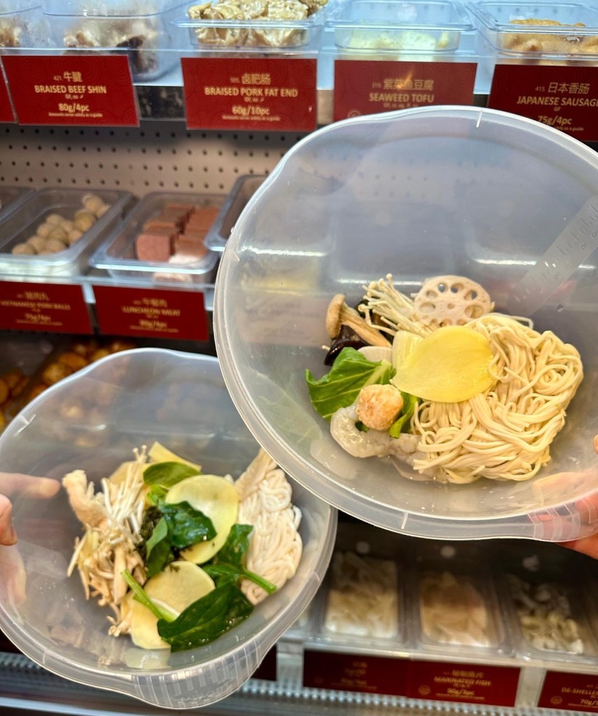 Two bowls filled with a variety of fresh Malatang ingredients, including vegetables, seafood, meats, and noodles, ready to be cooked.