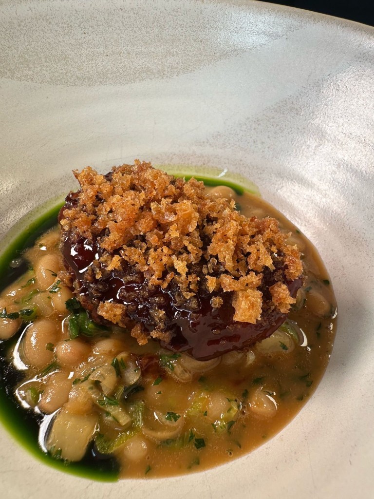 Slow-braised sticky pork cheek nestled in a rich cassoulet, topped with crispy sourdough crumb.