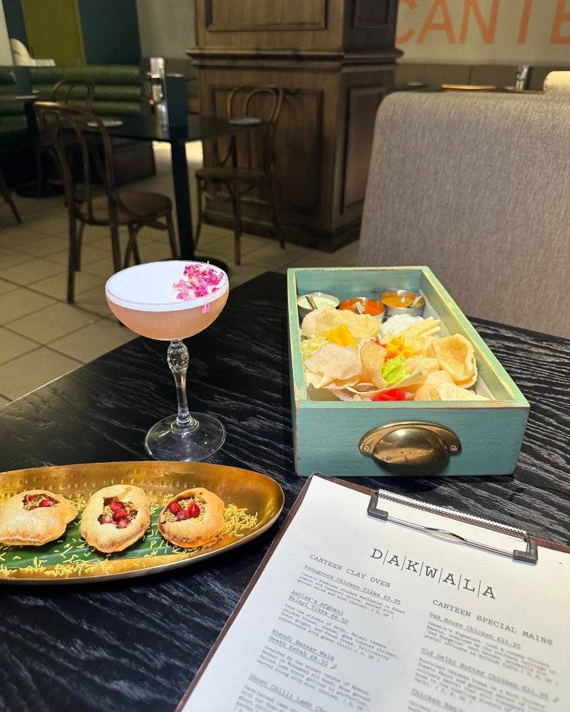 A plate of golden, crisp chaat bombs filled with tangy and spicy chutneys, garnished with fresh herbs.