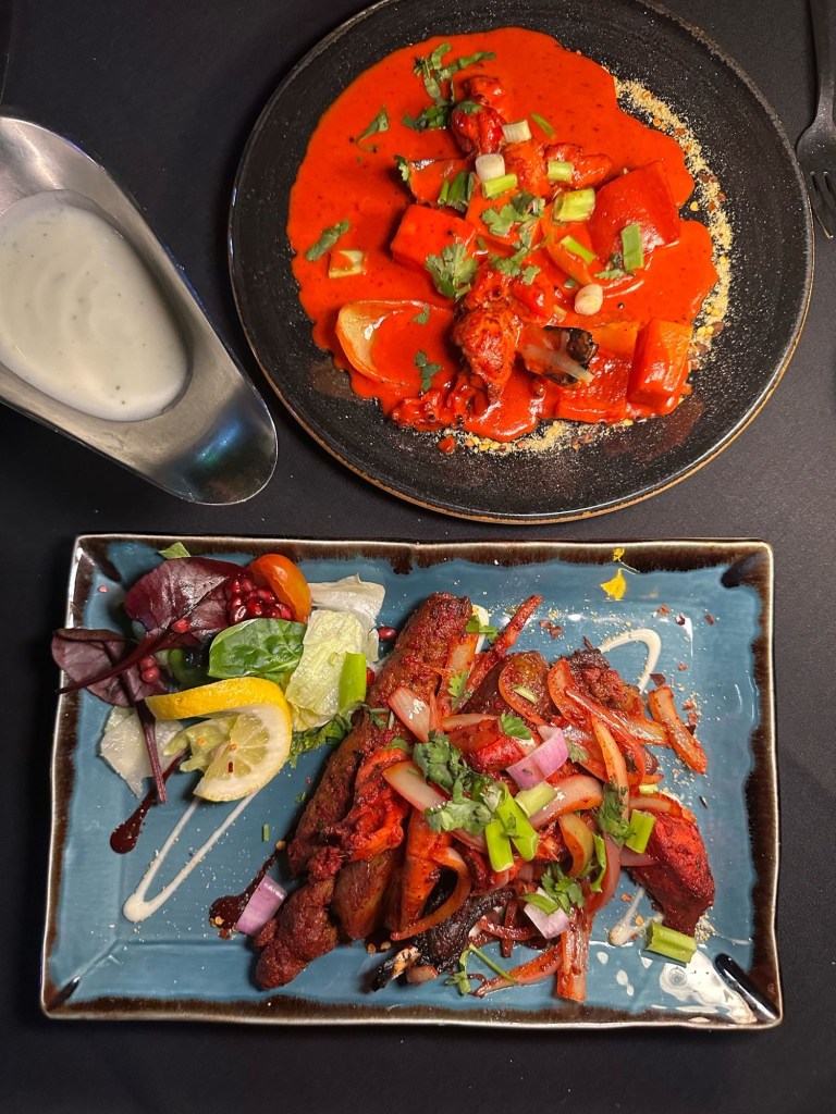 A delicious selection of Indian starters at Chester’s Lounge, including creamy dynamite prawns, spiced potatoes, and a mixed platter of meats and seafood.