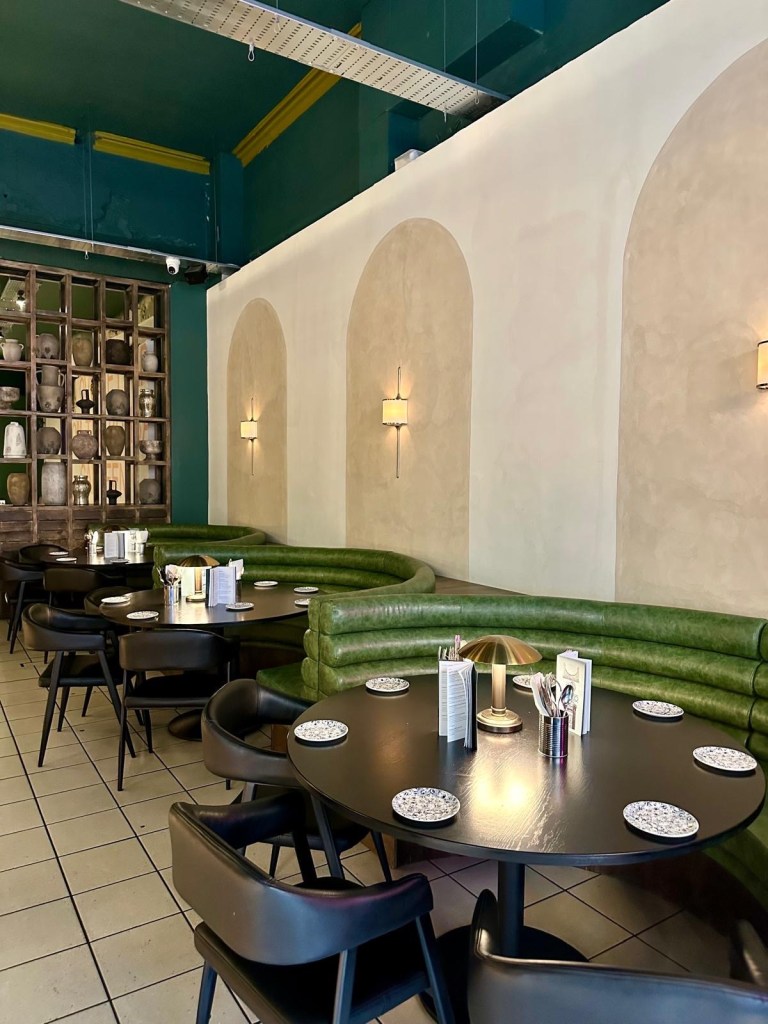 A sleek, dimly lit bar with high stools and a selection of premium spirits, perfect for cocktails and tapas.