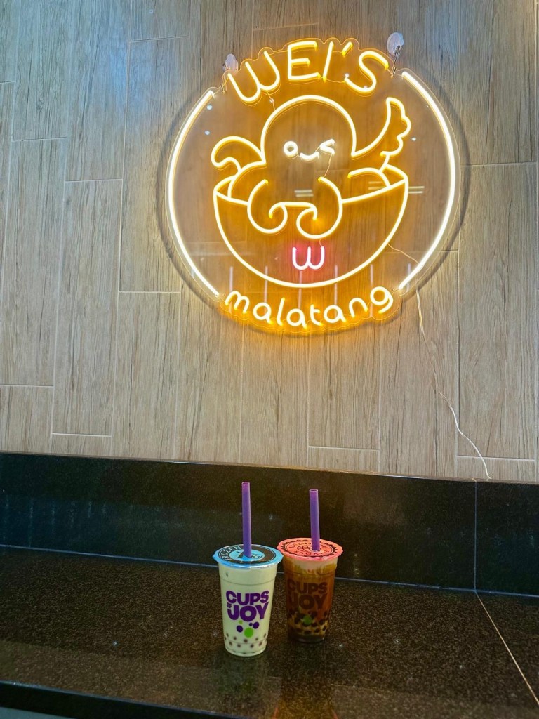 Two Chatime bubble teas, one matcha-flavored and one brown sugar, served in plastic cups with wide straws for tapioca pearls.