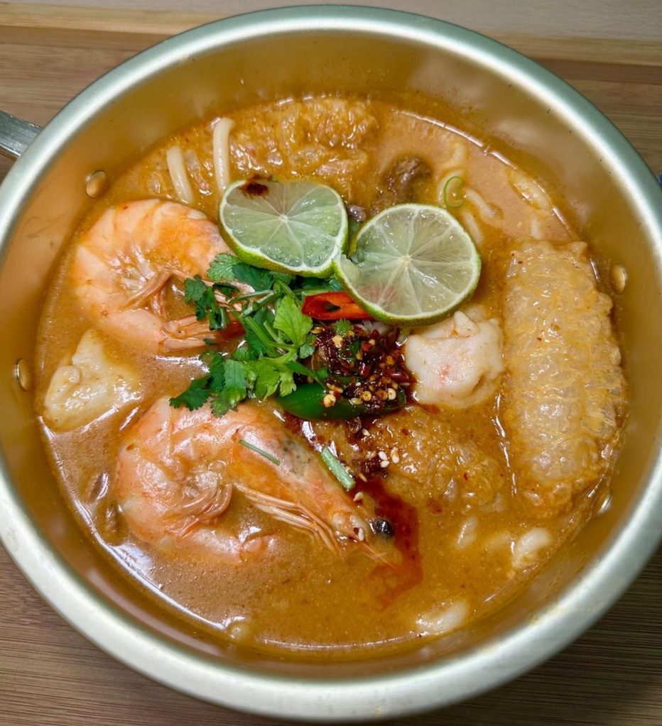 A variety of fresh seafood ingredients, including prawns, fish balls, squid, and mussels, ready to be added to a Malatang hot pot.