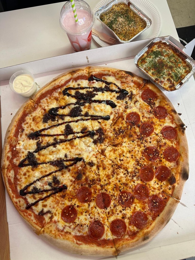 A large 20-inch New York-style pizza, half topped with spicy pepperoni and honey drizzle, and half with creamy goat’s cheese and red onion jam, served on a thin, crispy crust.