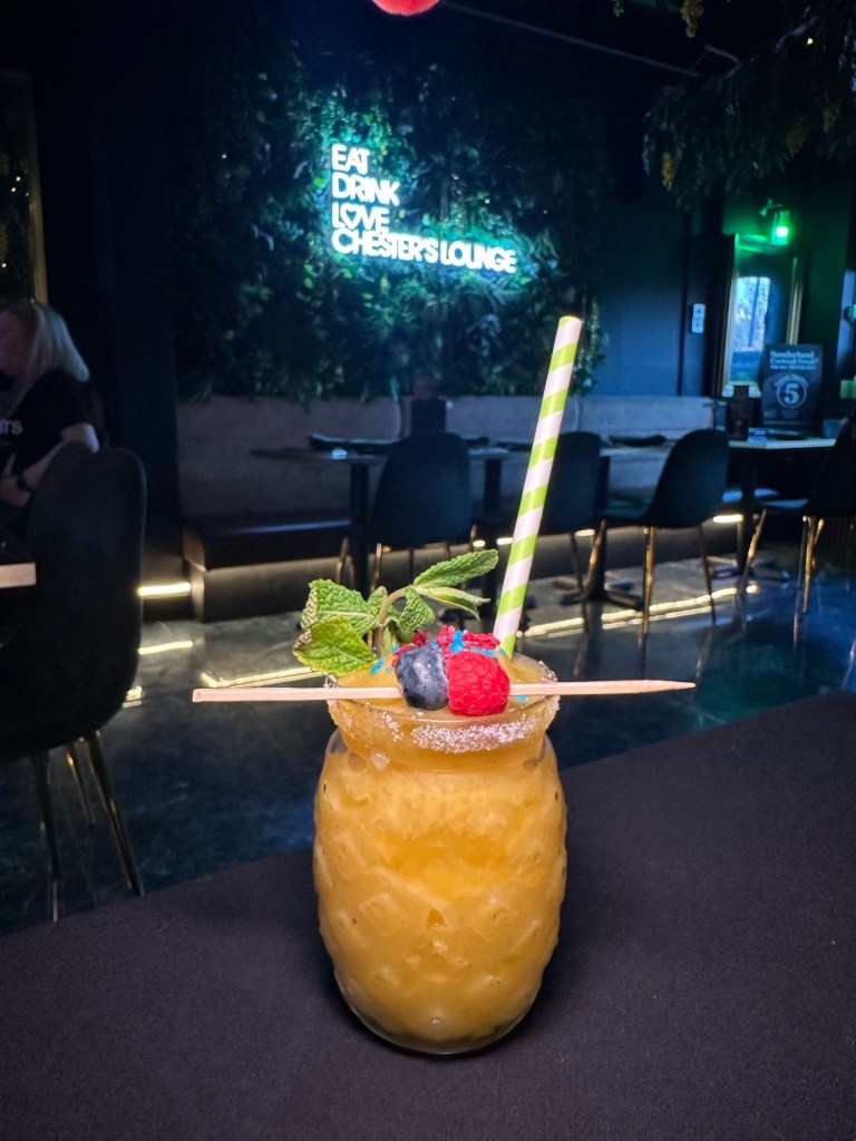 A tropical passion fruit and mango frozen cocktail served in a tall glass at Chester’s Lounge.