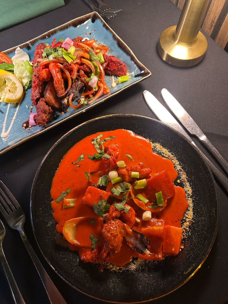 A delicious selection of Indian starters at Chester’s Lounge, including creamy dynamite prawns, spiced potatoes, and a mixed platter of meats and seafood.