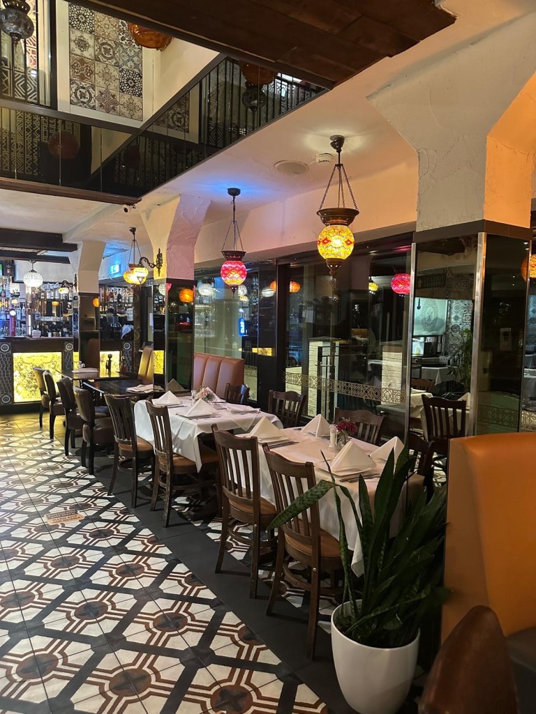 The elegant interior of Turknaz Restaurant, featuring warm lighting, traditional Turkish decor, and cozy seating by the seafront.
