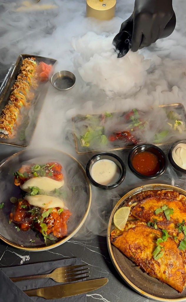 A spread of small plates from The Chamber South Shields, featuring bao buns, birria tacos, sushi rolls, lamb chops, kebabs, and crispy okra fries.