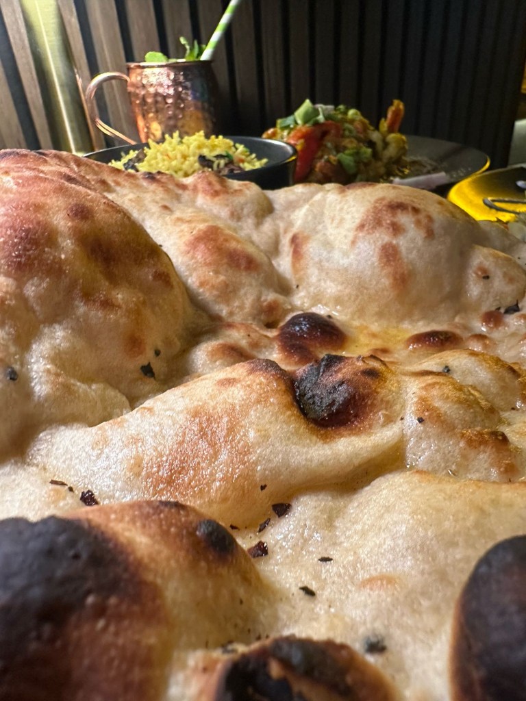Soft and fluffy naan bread served warm at Chester’s Lounge, perfect for dipping and scooping up flavorful curries.
