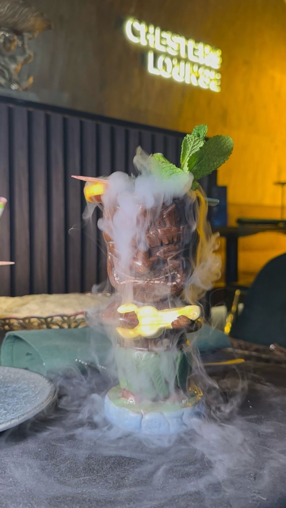 A vibrant green Sour Apple cocktail garnished with fresh mint and lime at Chester’s Lounge.