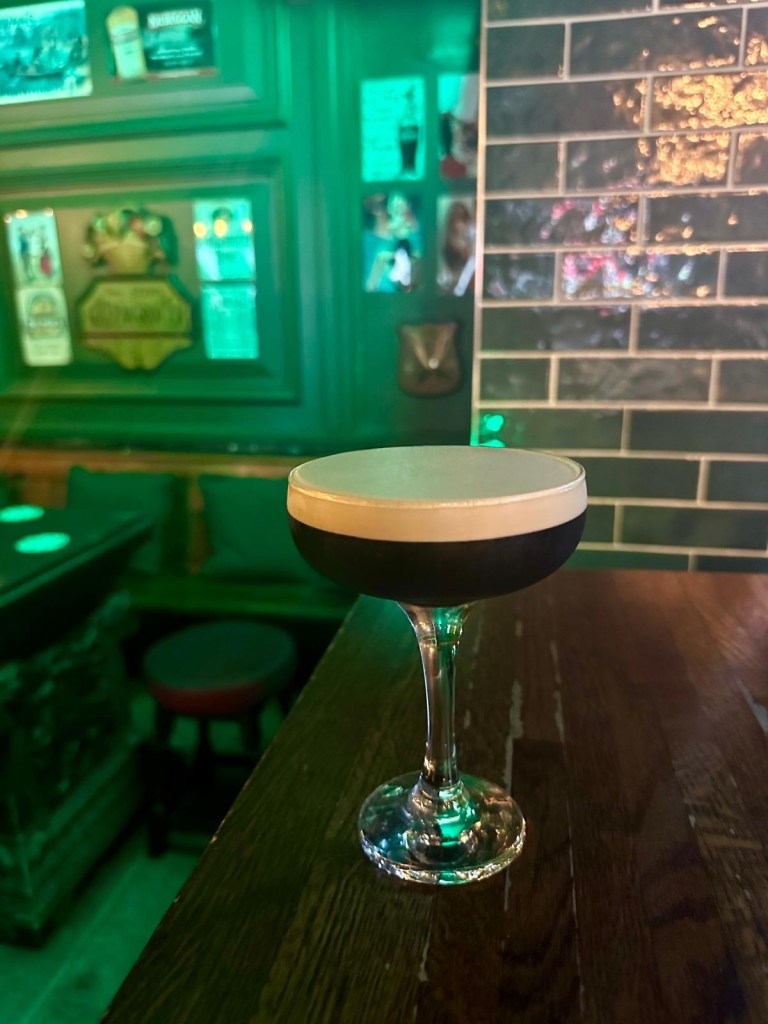 A lineup of colorful cocktails served in elegant glassware on a bar counter.