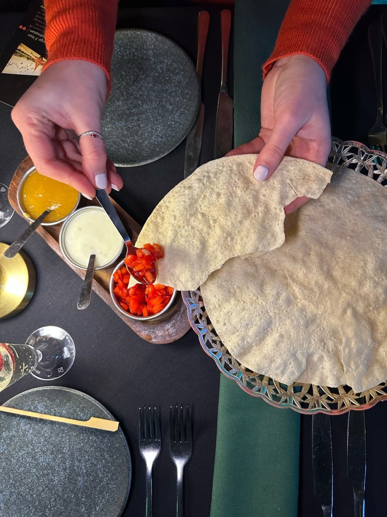 A traditional Indian pickle tray with crispy poppadoms, chutneys, and dips at Chester’s Lounge.