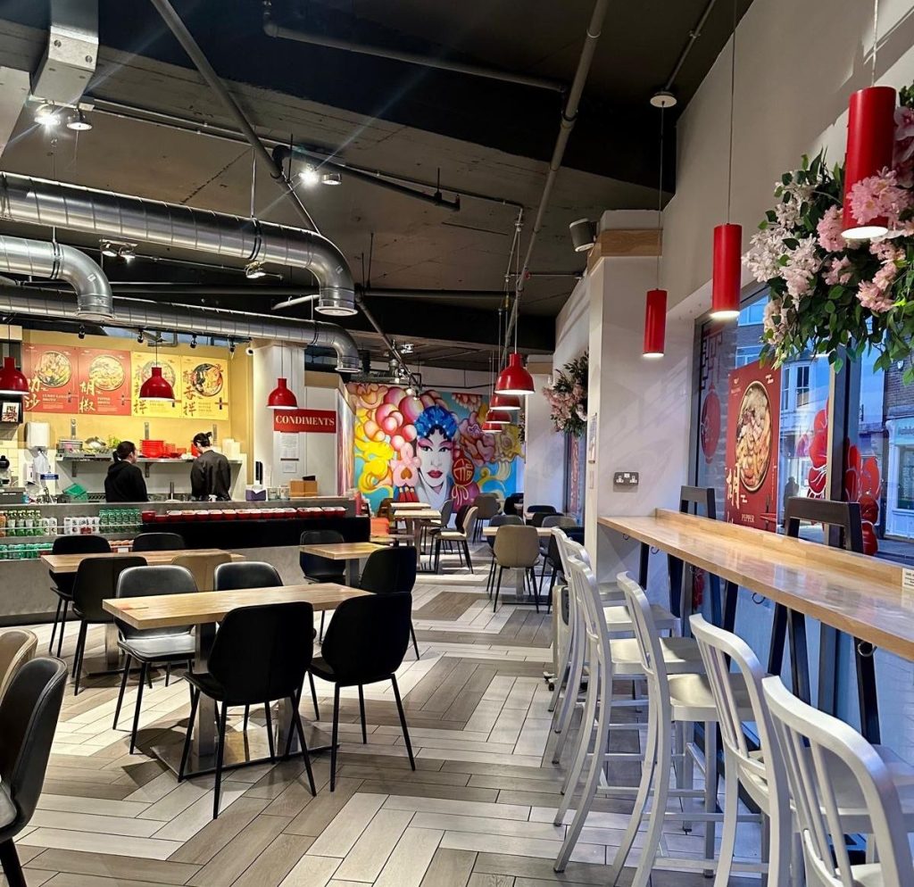 The bright and airy interior of Malatang Express in Durham, featuring stylish wall art and modern seating.