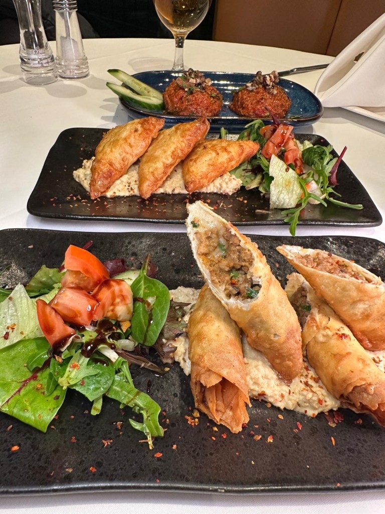 Deep-fried filo pastry parcels stuffed with minced meat, onions, cheese, and parsley, served hot at Turknaz Restaurant.