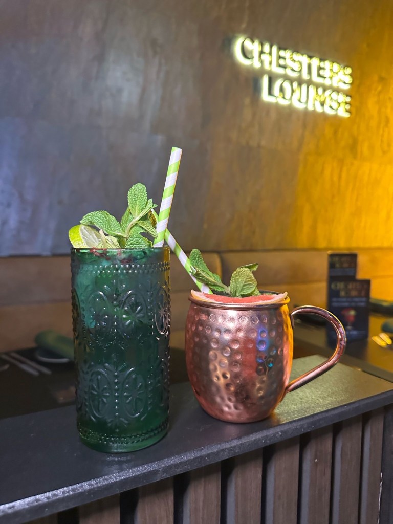 A refreshing Kiwi Wzrd and Lychee Spritz cocktail duo at Chester’s Lounge, served with fresh fruit garnishes.