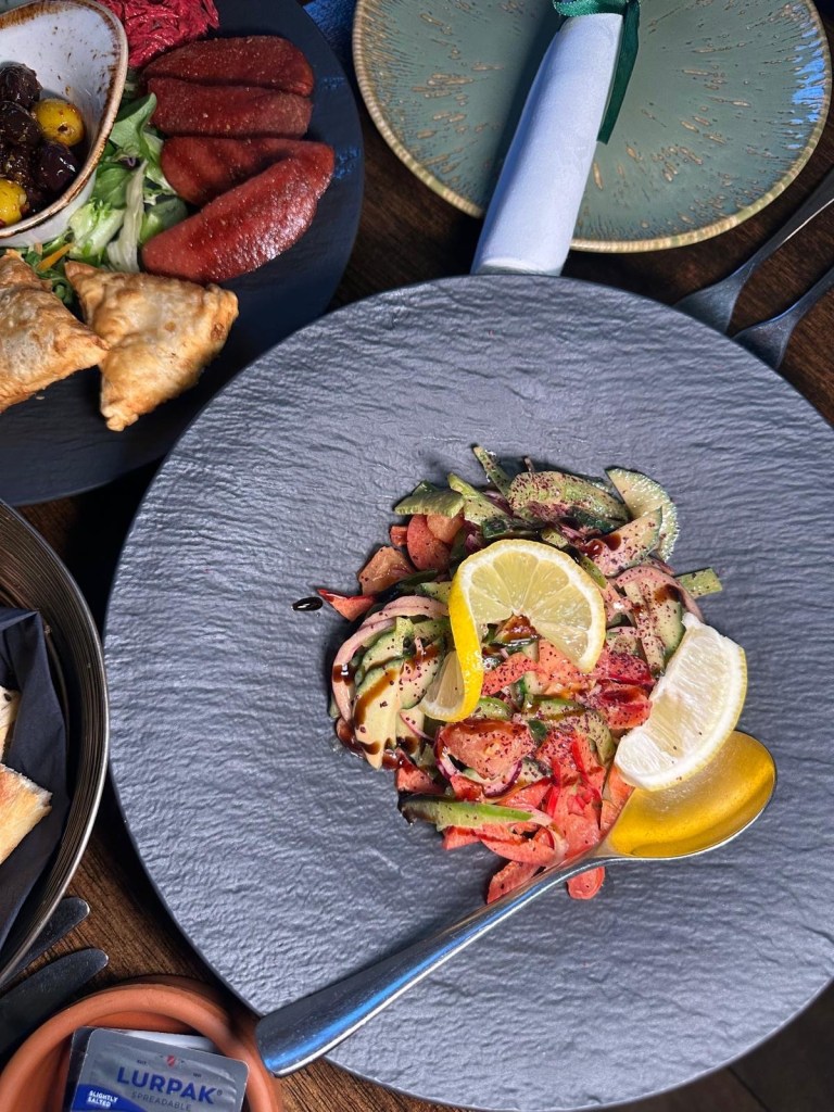 A fresh Turkish shepherd salad with tomatoes, cucumbers, green peppers, and onions, dressed in olive oil and lemon at Lezzet Newcastle.