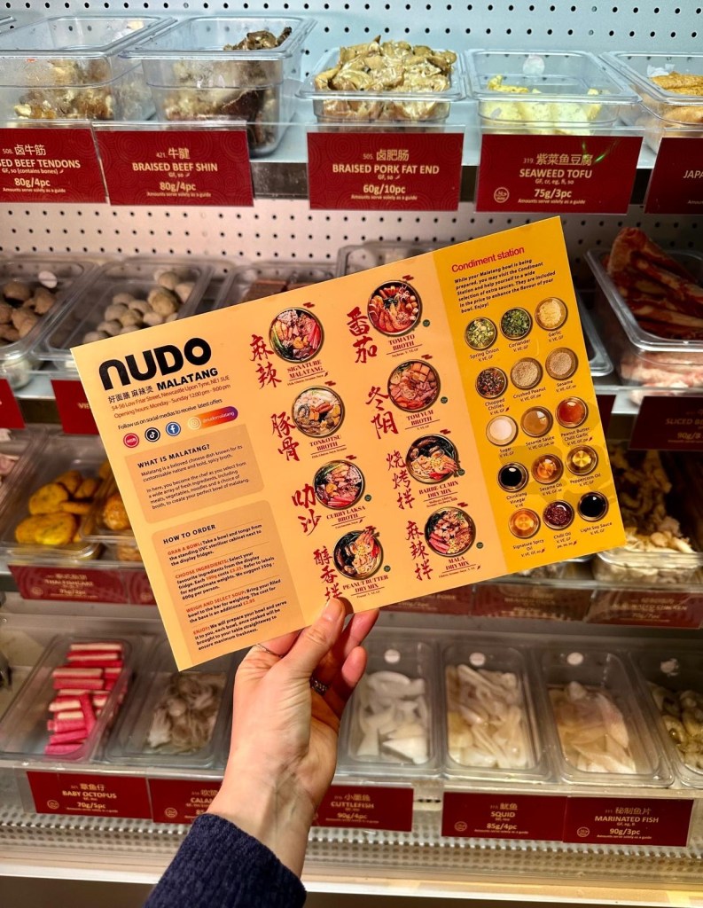 The menu at Nudo Malatang displayed in front of the self-serve ingredient fridges.