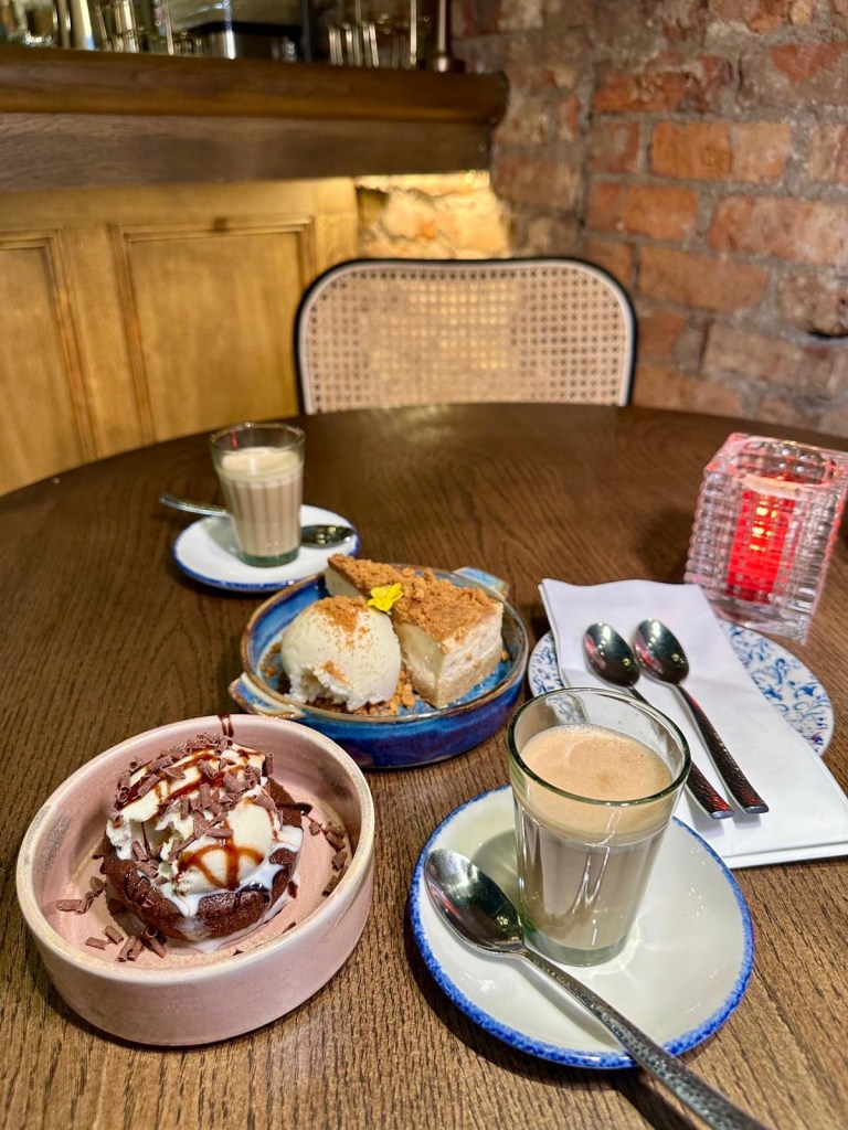 A duo of decadent desserts featuring a creamy cheesecake with fresh berries and a rich chocolate bomb with warm sauce.