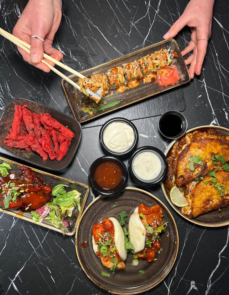 A spread of small plates from The Chamber South Shields, featuring bao buns, birria tacos, sushi rolls, lamb chops, kebabs, and crispy okra fries.