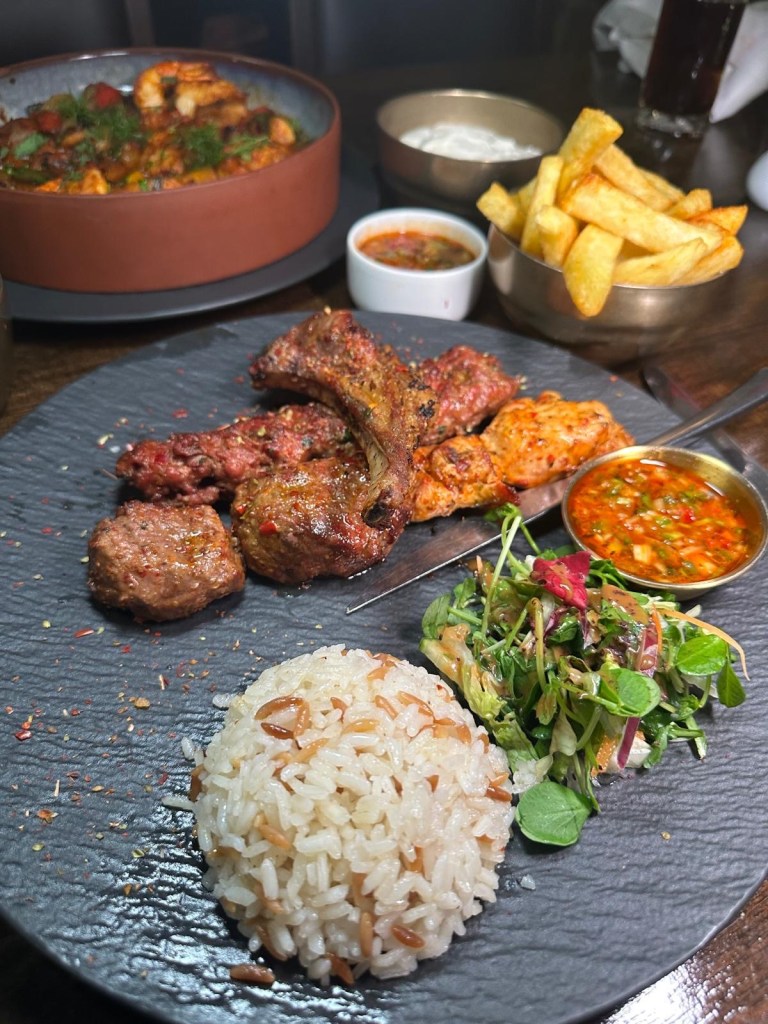 Lezzet Newcastle's Mix Grill with Adana, chicken shish, lamb shish, and lamb chop, served with rice, salad, and chili sauce