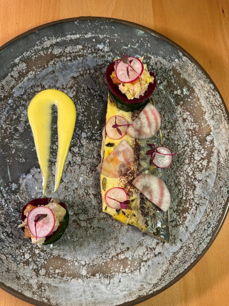 A beautifully plated dish of mackerel escabeche, topped with silky saffron mayonnaise and served with crisp sourdough and cucumber.