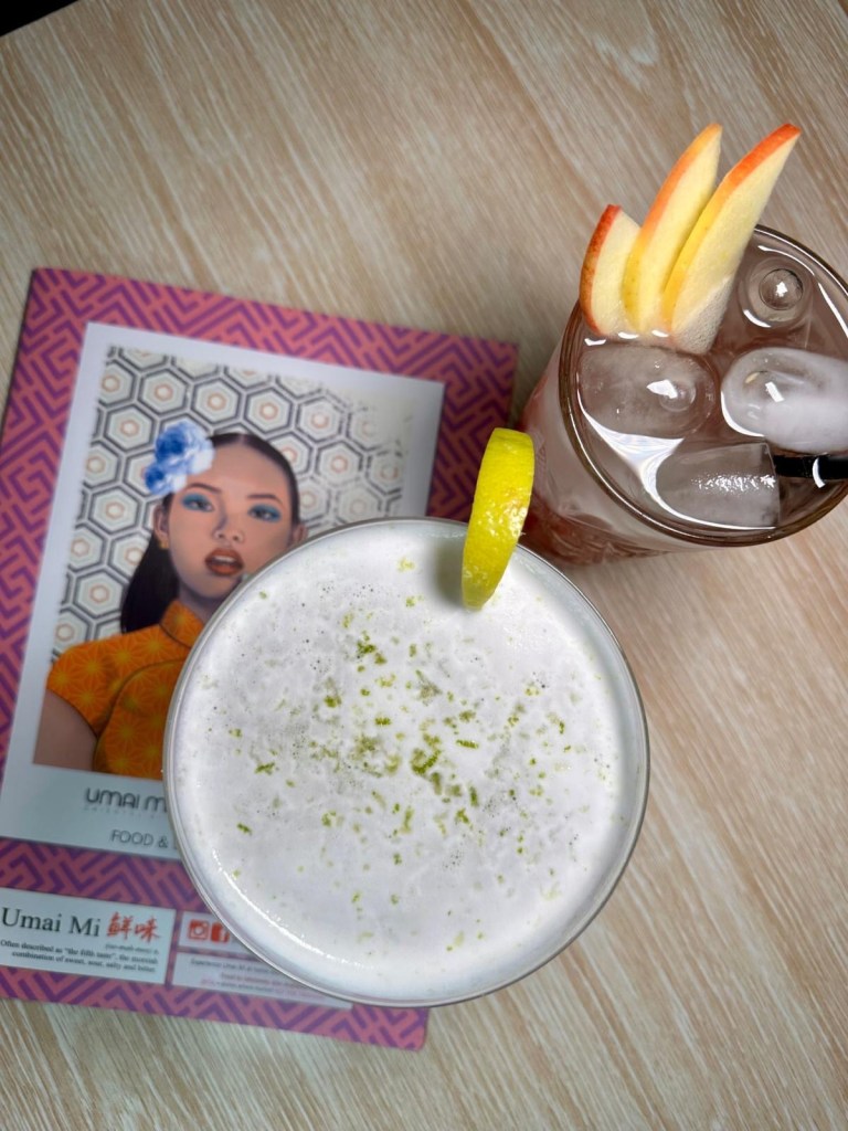 A Wasabitini cocktail with a citrus twist alongside an Orchid Twilight softail, elegantly presented with fresh fruit garnishes.