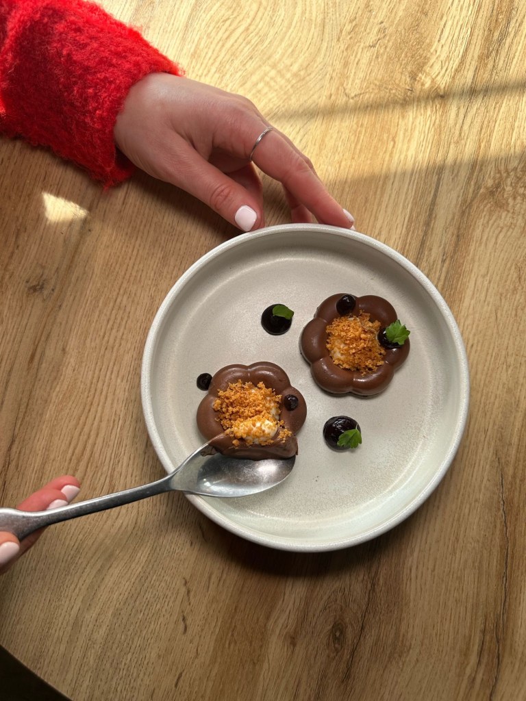 A rich chocolate cremeux with glossy cherry gel, served with a delicate baked cheesecake and crunchy cookie crumb.