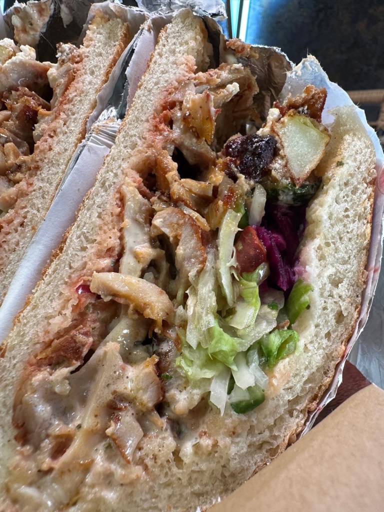 Generous serving of homemade chicken doner in crispy pide bread with vegetables and feta
