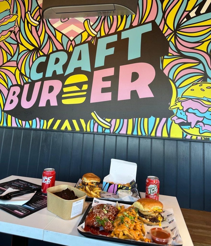 Full table spread of Craft Burger food at the Gosforth branch including burgers, loaded fries, tenders, tots, dips, and drinks.