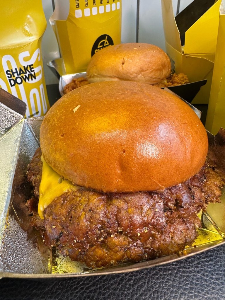 Four stacked smash burger patties with melted cheese and signature sauce from Shakedown Jesmond.