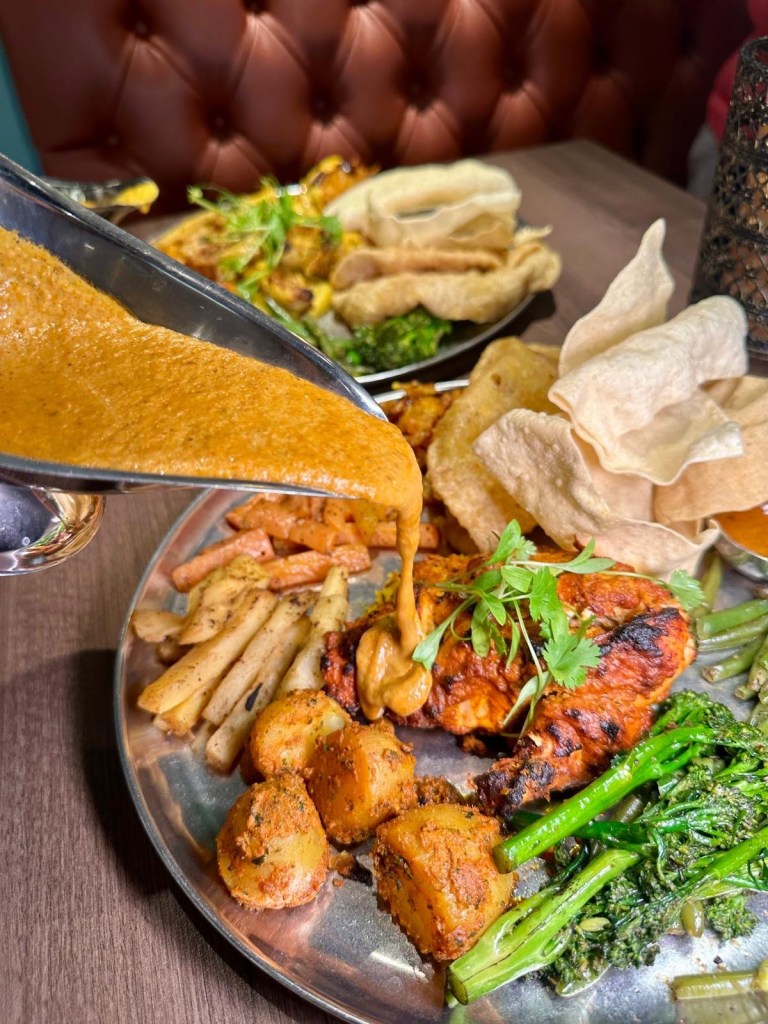 Ultimate Indian Sunday roast platter with tandoori meats, sides, and gravies at Chakh Dhoom