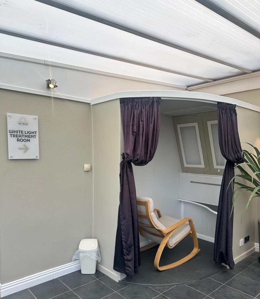 Serene white light treatment room with calming ambiance at High Hill Stay spa.