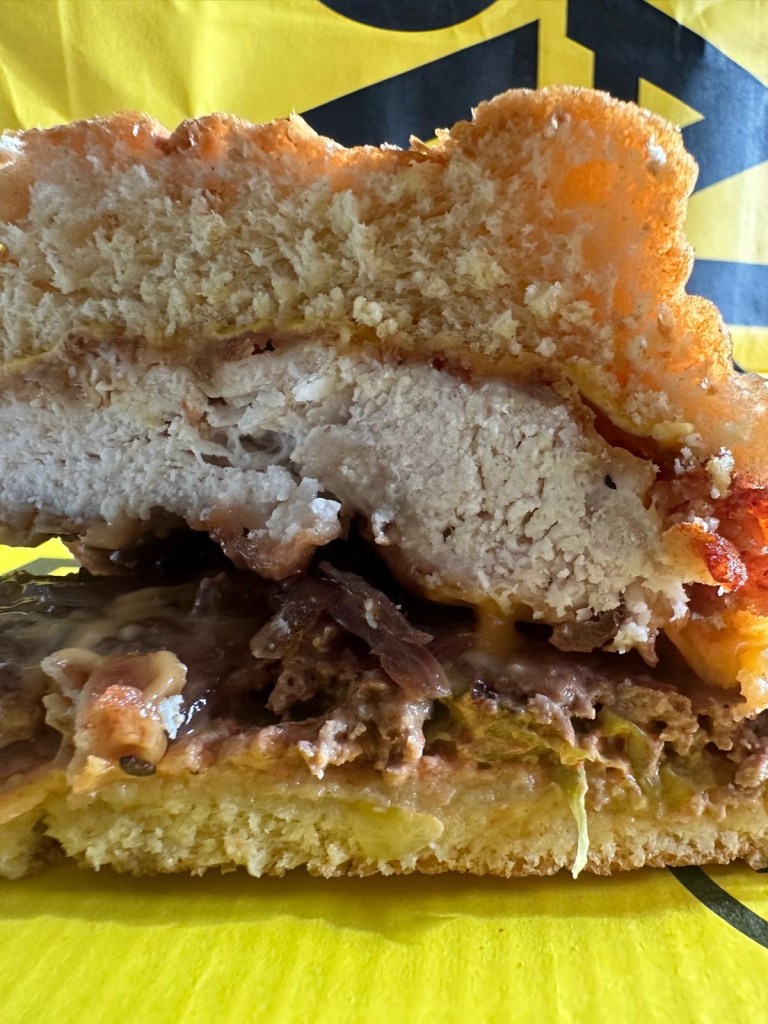 Hearty Stack Sandwich with chicken and beef patties, cheese, and sauce at Shakedown Newcastle.