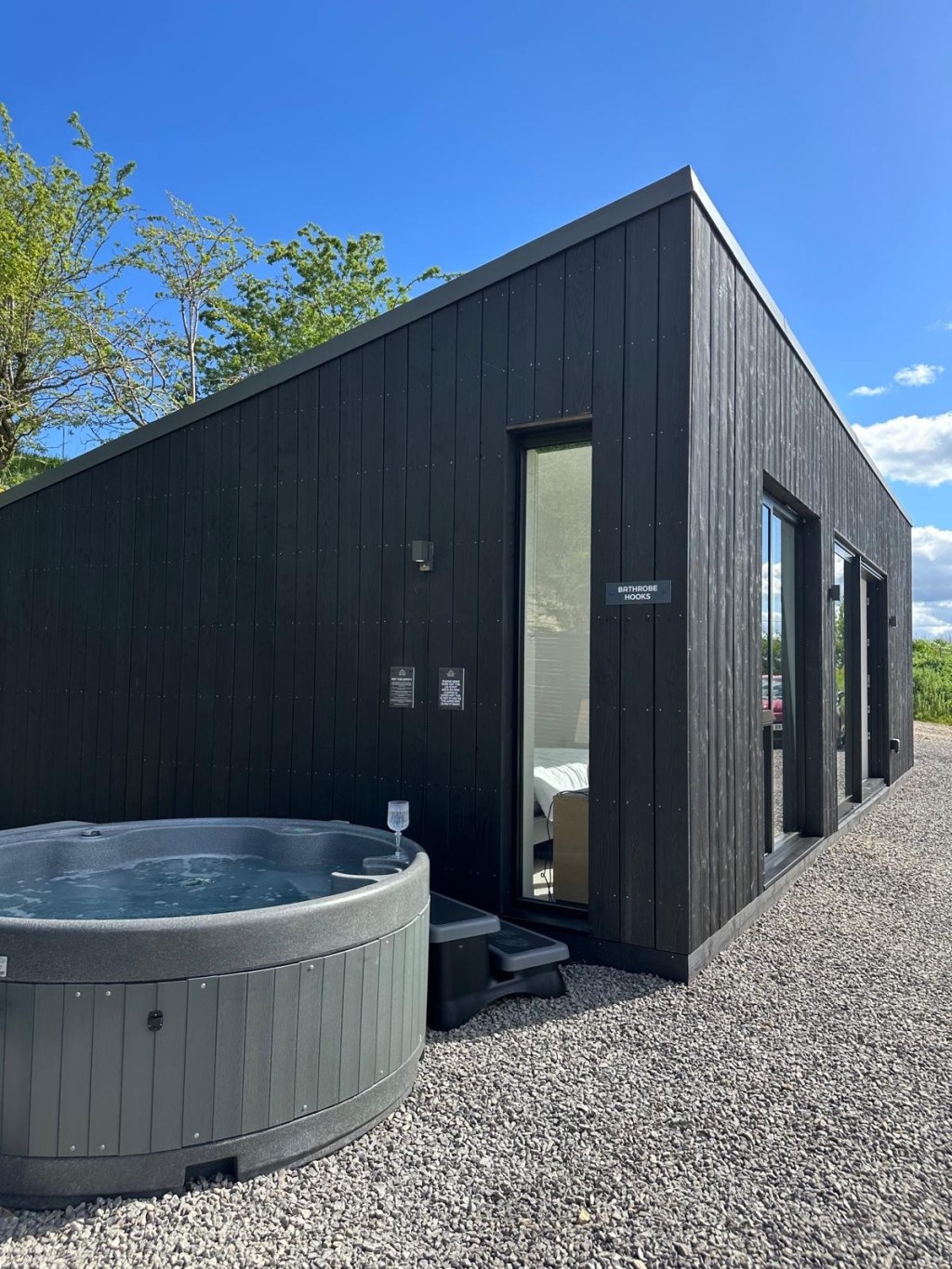 Exterior of High Hill Stay’s Valley Lodge with rural landscape and private outdoor area with hot tub.