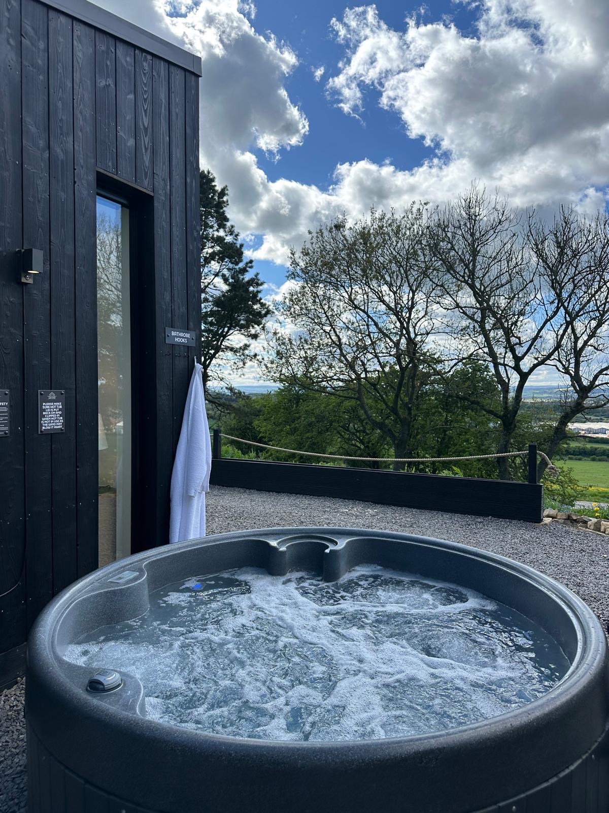 Private outdoor hot tub overlooking Durham countryside at High Hill Stay lodge.