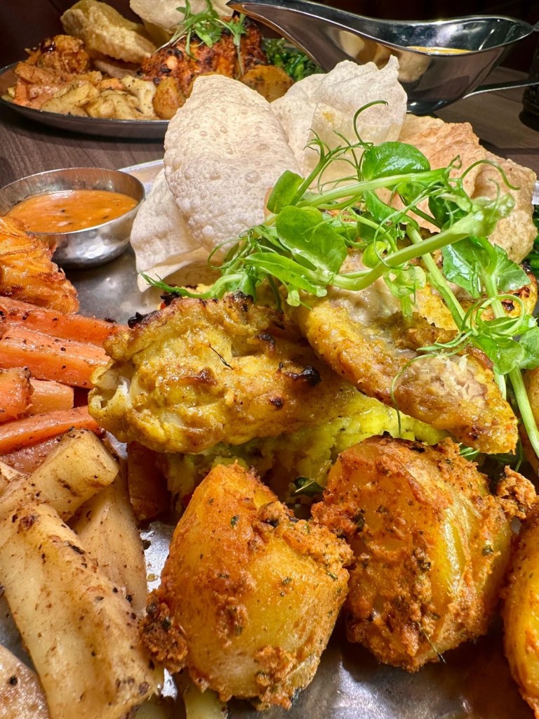 Ultimate Indian Sunday roast platter with tandoori meats, sides, and gravies at Chakh Dhoom