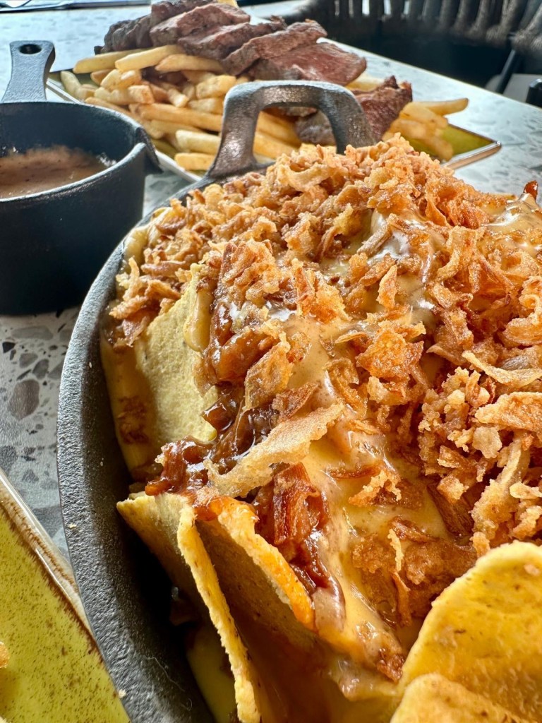 Loaded nachos with BBQ pulled pork, cheese sauce, and crispy onions at River Bar Washington