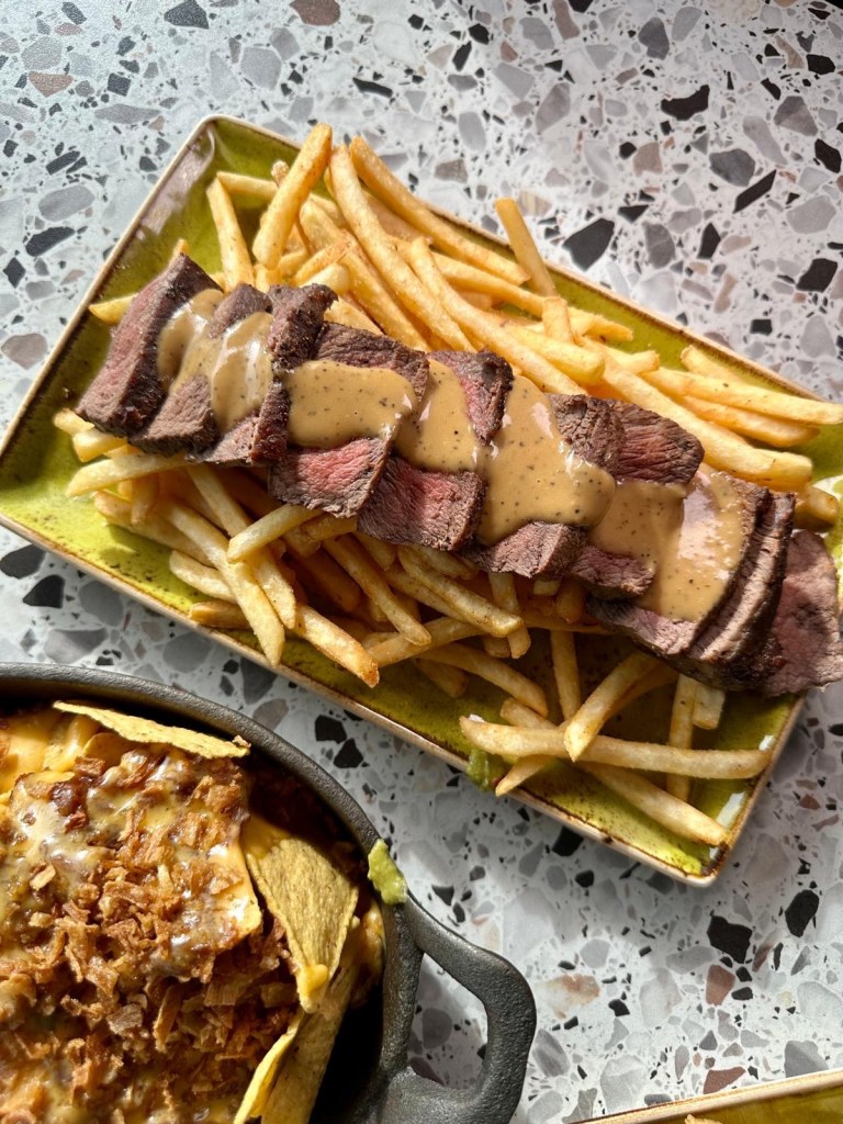 Flat iron steak with crispy seasoned fries and peppercorn sauce at River Bar Washington