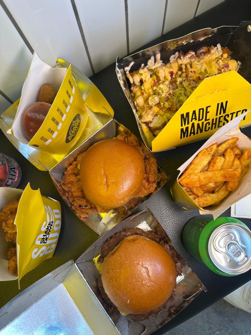 Full spread of Shakedown Jesmond food including smash burgers, loaded fries, chicken tenders, mozzarella dips, and waffle dessert.