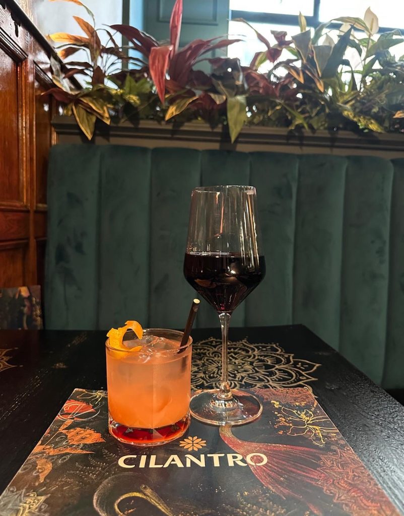 Cilantro Sunrise mocktail and glass of red wine at Cilantro Tapas Newcastle