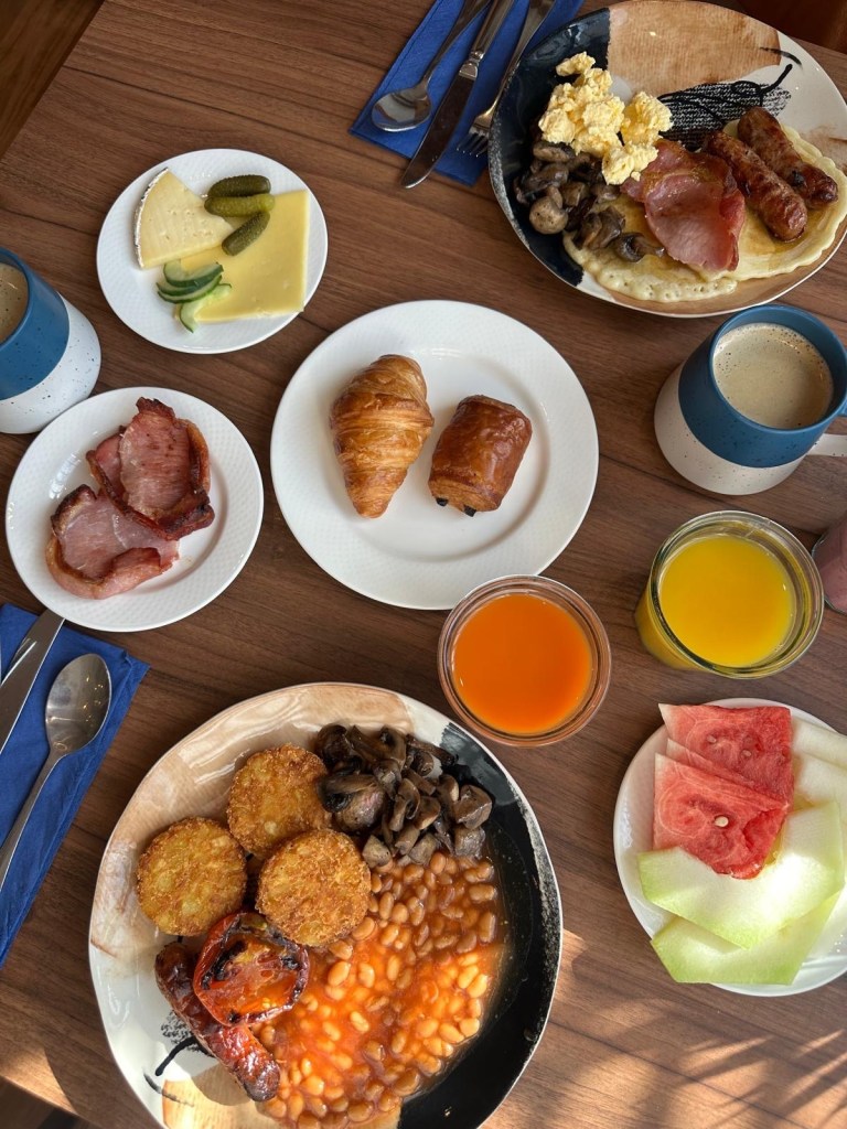 Bird’s-eye view of hotel breakfast spread with cooked breakfast, pastries, fresh fruit, pancakes, and continental options at Radisson Blu Durham