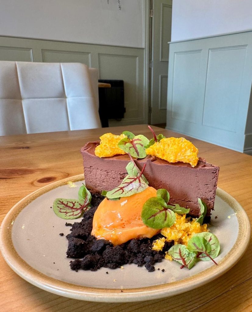 Rich Oreo torte with puffed mandarin pieces and mandarin sorbet at Isla in Durham.