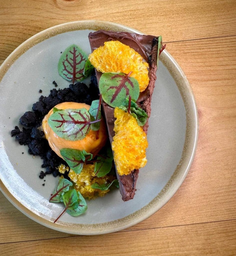 Rich Oreo torte with puffed mandarin pieces and mandarin sorbet at Isla in Durham.