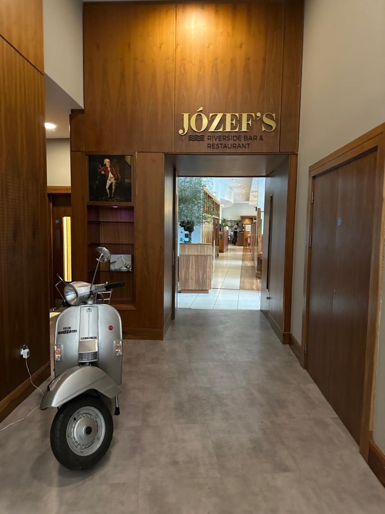 Jozef’s Restaurant entrance at Radisson Blu Durham with a vintage-style scooter parked outside