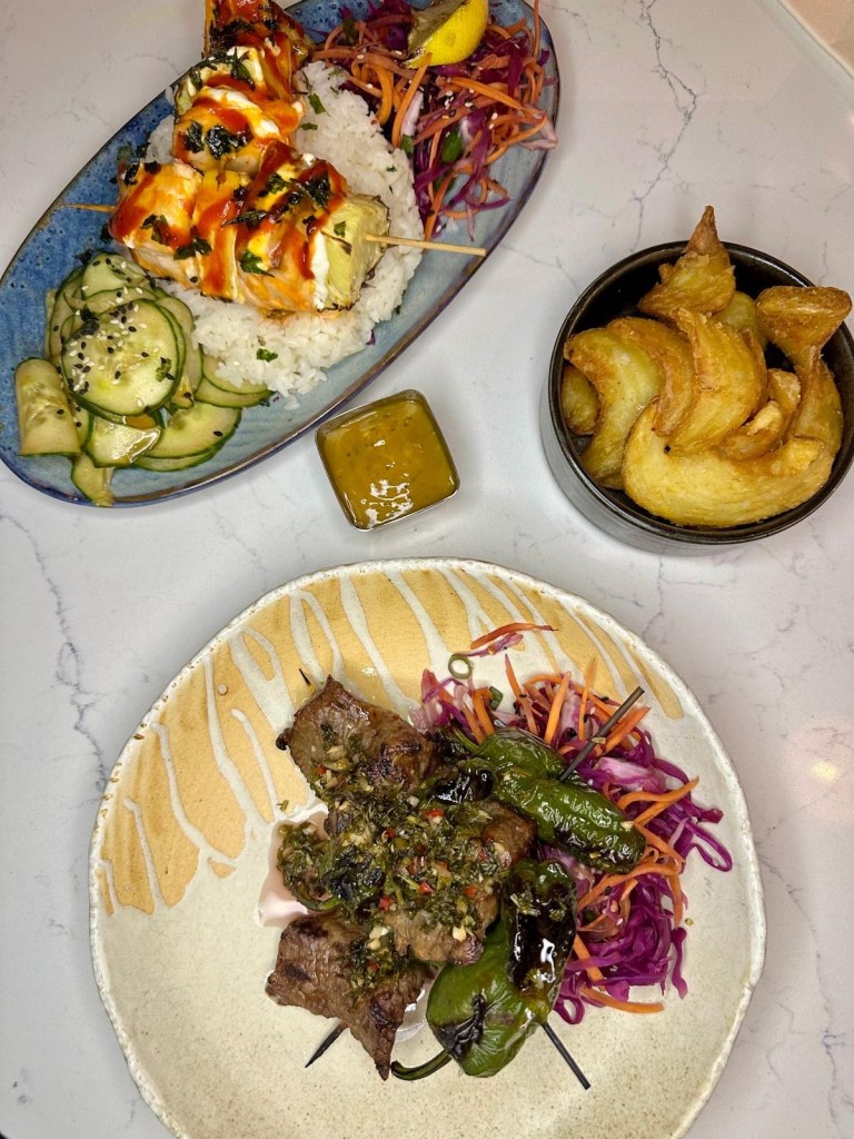 Grilled salmon and steak skewers with sticky rice, chips, pineapple, and slaw at Moku Newcastle