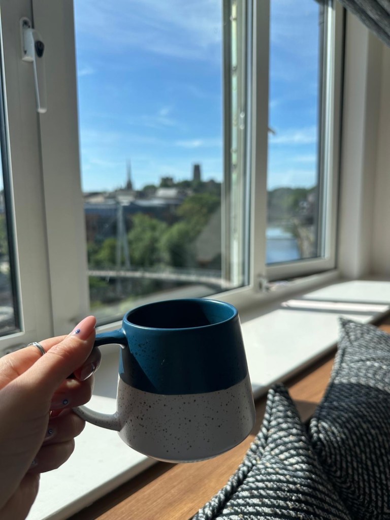 Coffee cup on windowsill overlooking Durham cityscape and river from Radisson Blu Durham top floor room
